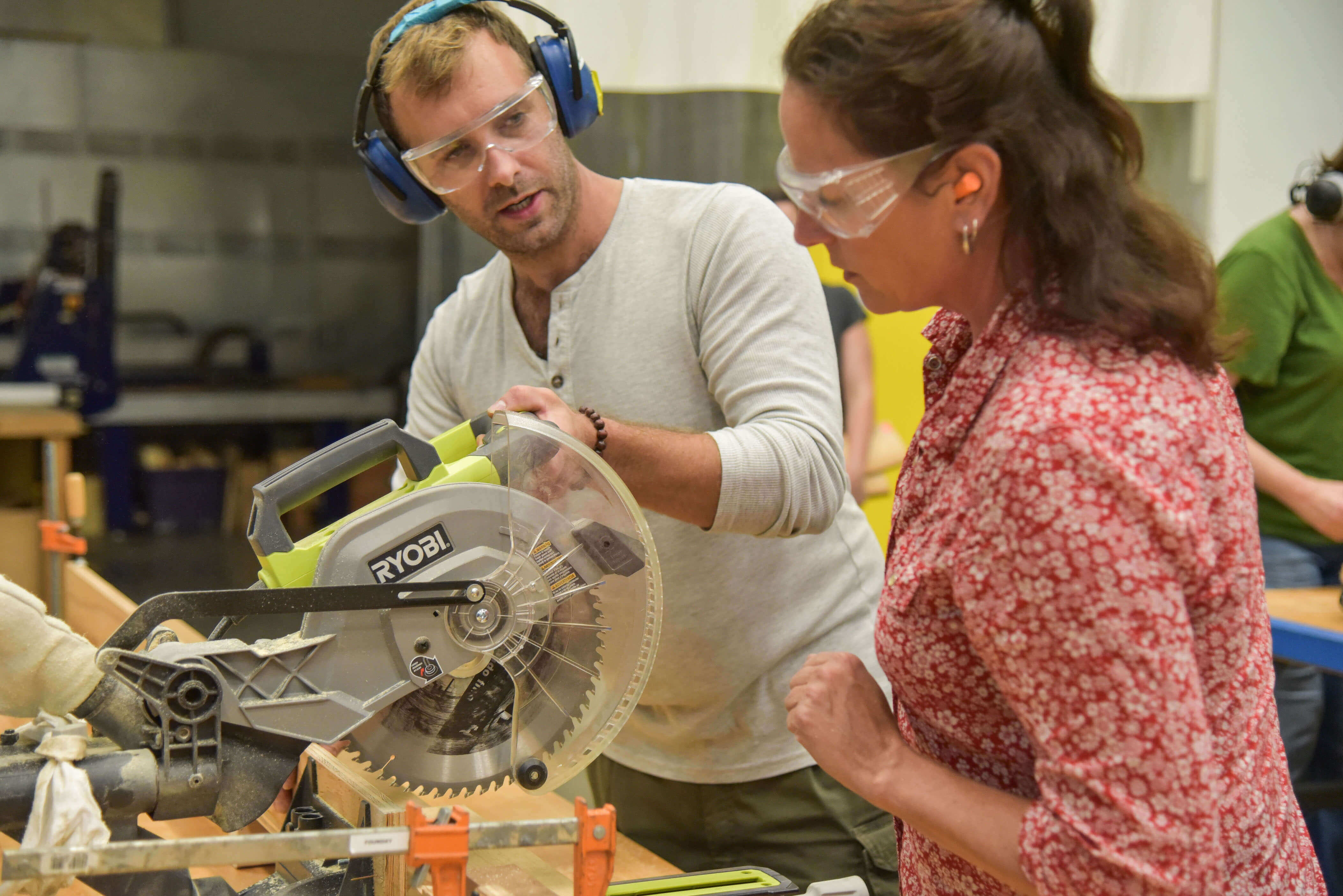 Instructor teaching student how to use chop saw