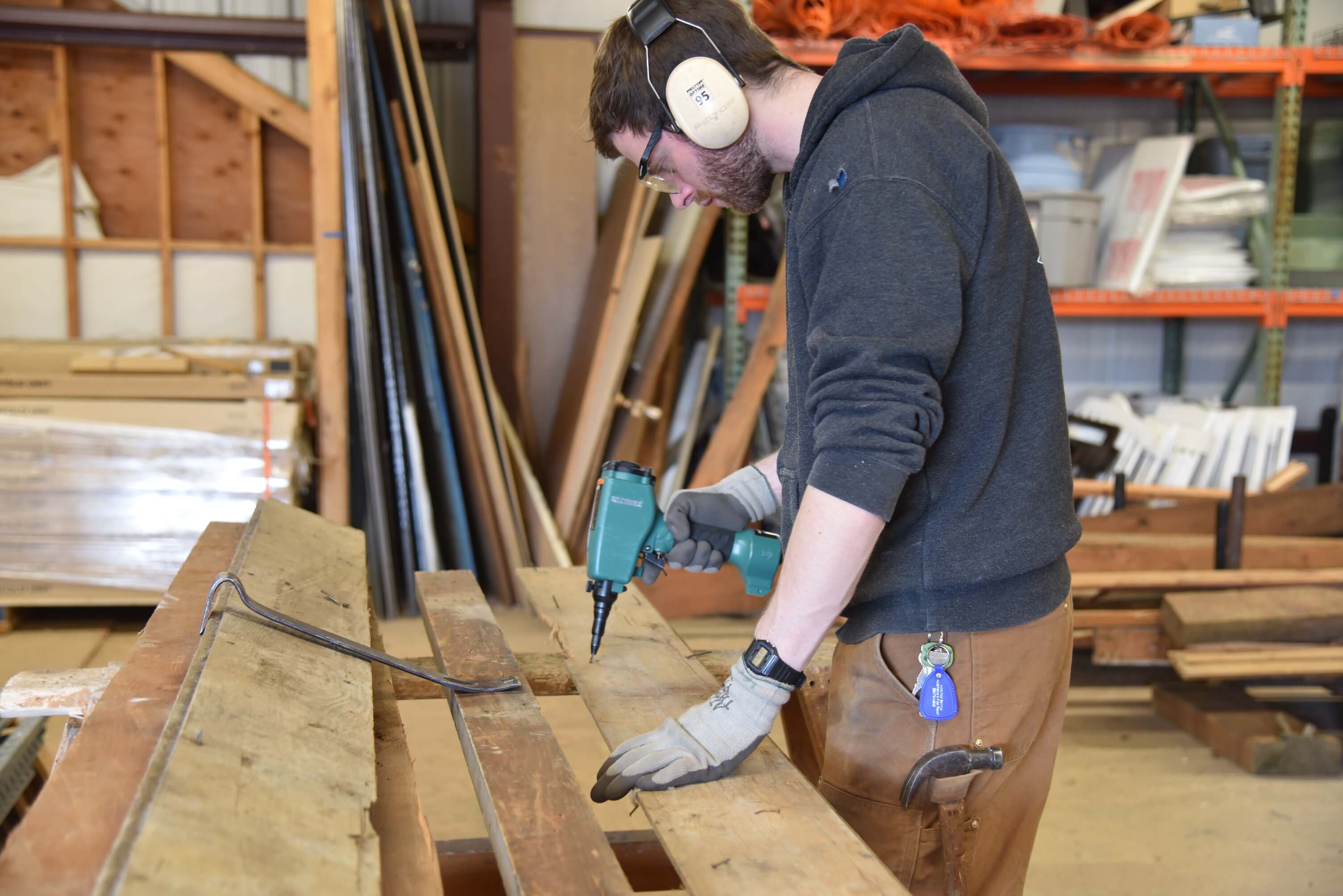 Salvage crew member, Spencer using the Nail Kicker to remove nails from lumber