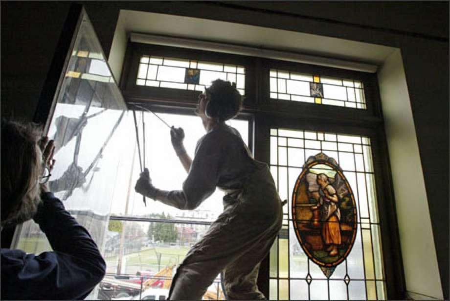 RE Store staff removing a stained glass window