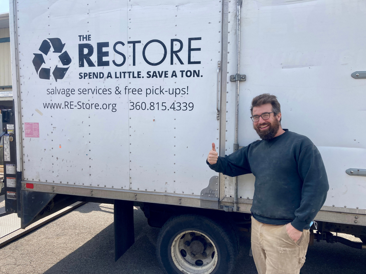 Tim O'Donnell smiling next to The RE Store truck