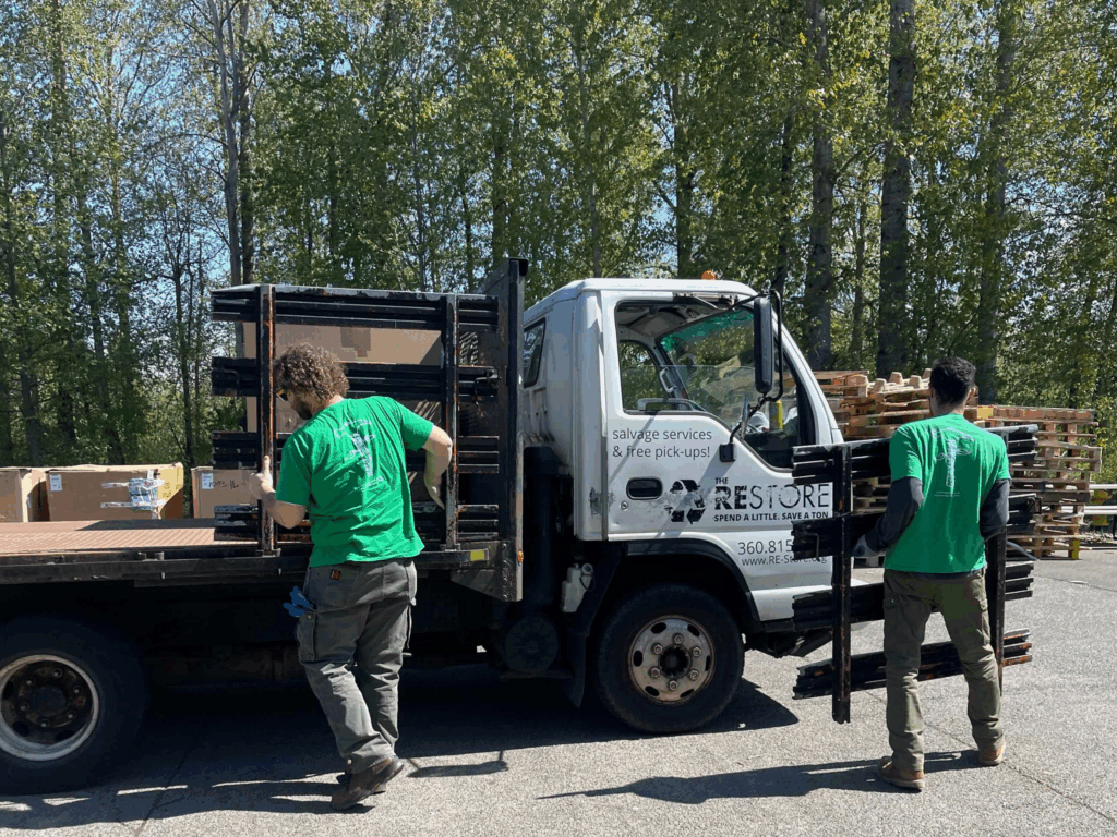 two re store crew members are loading a truck with salvaged materials